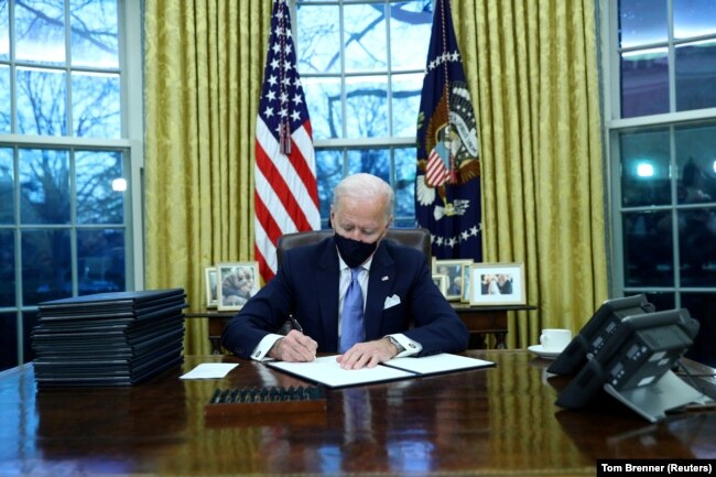 АҚШ-тың 46-президенті Джо Байден алғашқы құжаттарына қол қойып жатыр. 20 қаңтар 2021 жыл.
