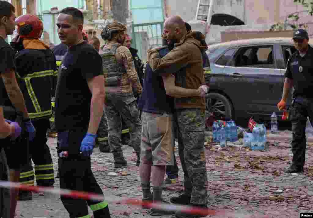 Військовий втішає Ярослава, який втратив дружину і доньок. На місці влучення російської ракети. Львів, 4 вересня 2024 року