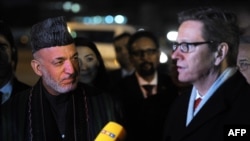 Afghan President Hamid Karzai (left) and German Foreign Minister Guido Westerwelle speak to reporters upon Karzai's arrival in Germany for the Bonn II conference on December 5.