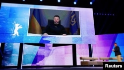 Sean Penn stands on the stage as Ukraine's President Volodymyr Zelenskiy addresses the audience via video link during the opening gala of the 73rd Berlinale International Film Festival in Berlin on February 16.