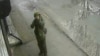 Російський солдат цілиться у вуличну камеру під час окупації міста Буча. Київщина, Україна. Березень 2022 року