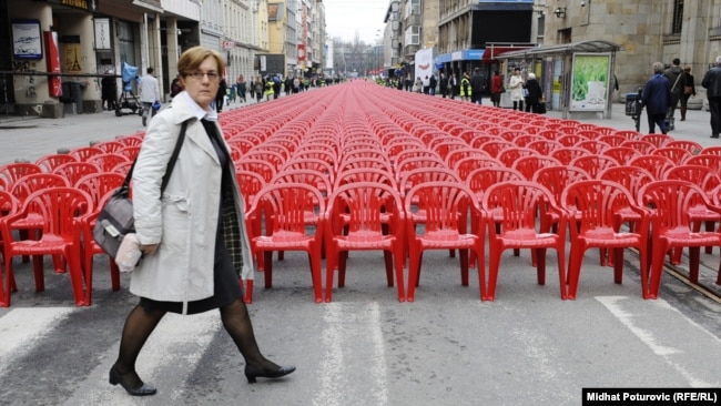 Жена пресича улица в Сараево, на която са поставени празни столове - по един за всеки от жителите на града, убити по време на обсадата от 1992 до 1996 г. Снимката е от 6 април 2012 г.