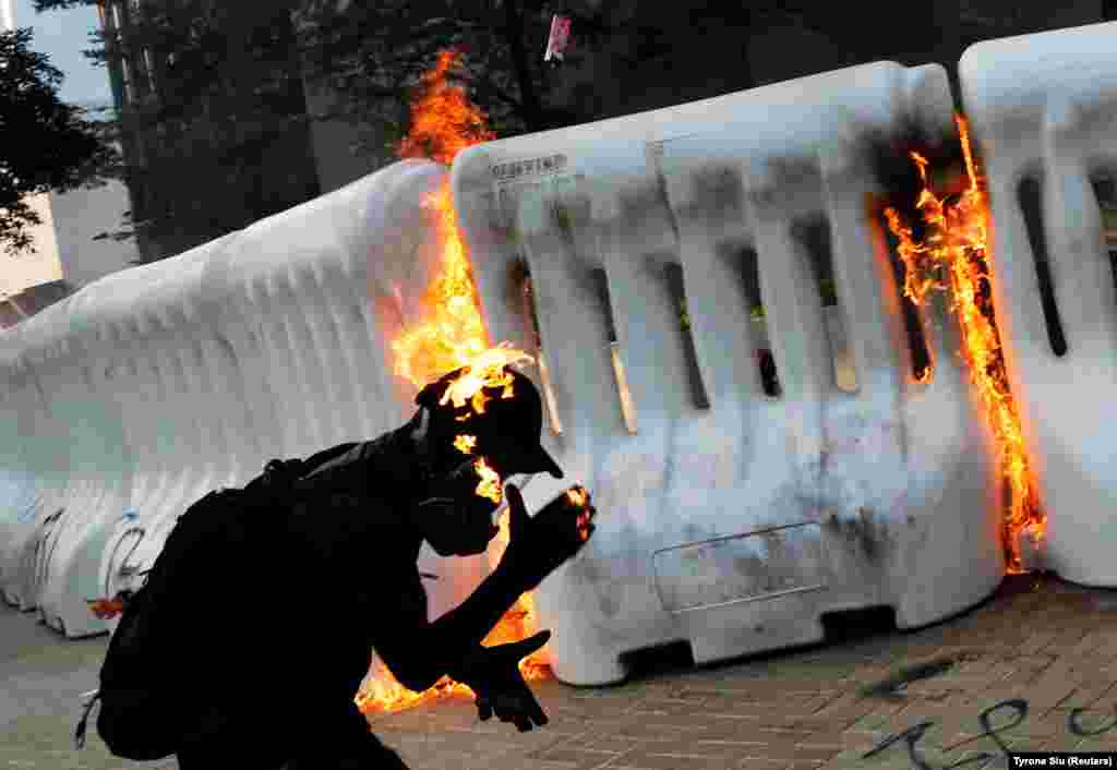 An anti-government protester catches fire after throwing a Molotov cocktail during a demonstration in Hong Kong. (Reuters/Tyrone Siu)