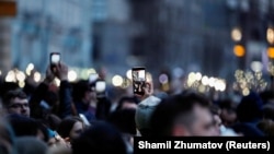 Сторонники Алексея Навального держат мобильные телефоны с включенным светом во время митинга в Москве, 21 апреля 2021 года