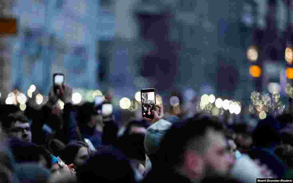 Supporters of jailed Russian opposition leader Aleksei Navalny hold up phones with the lights on during a rally in Moscow on April 21. (Reuters/Shamil Zhumatov)