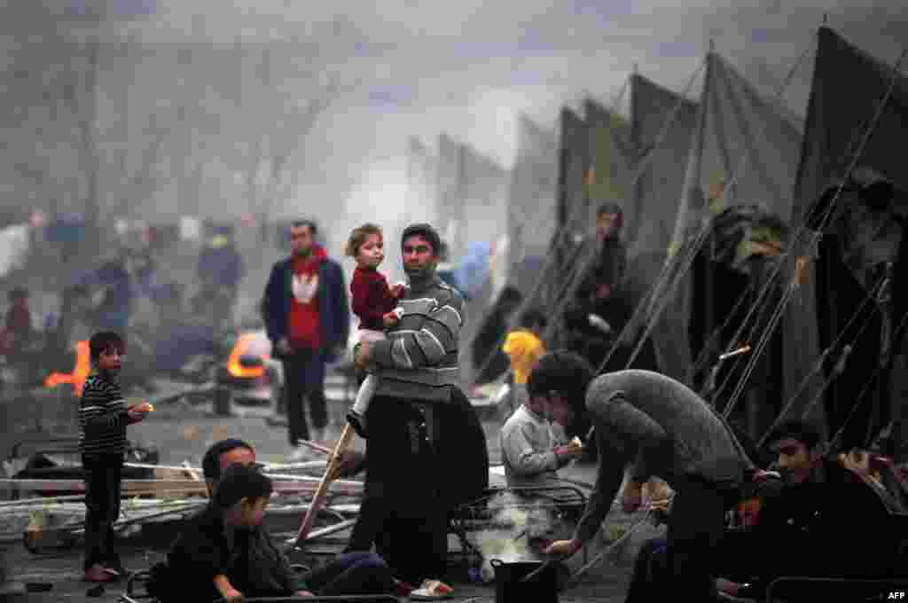 A Syrian refugee holds a baby in a refugee camp set in the town of Harmanli, southeast of Sofia, on November 12. (AFP/Nikolay Doychino)