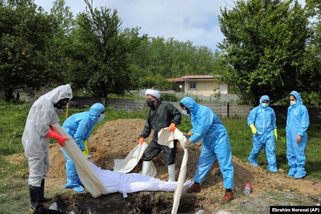 Люди в захисному спорядженні ховають померлих від коронавірусу на околиці міста Гемшахр на півночі Ірану. 1 травня 2020 року