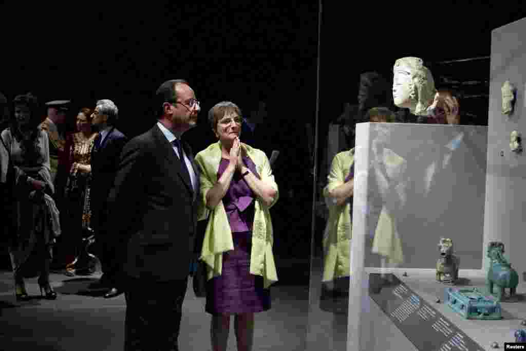 French President Francois Hollande listens to Sophie Makariou, the head of the Islamic Arts Department.