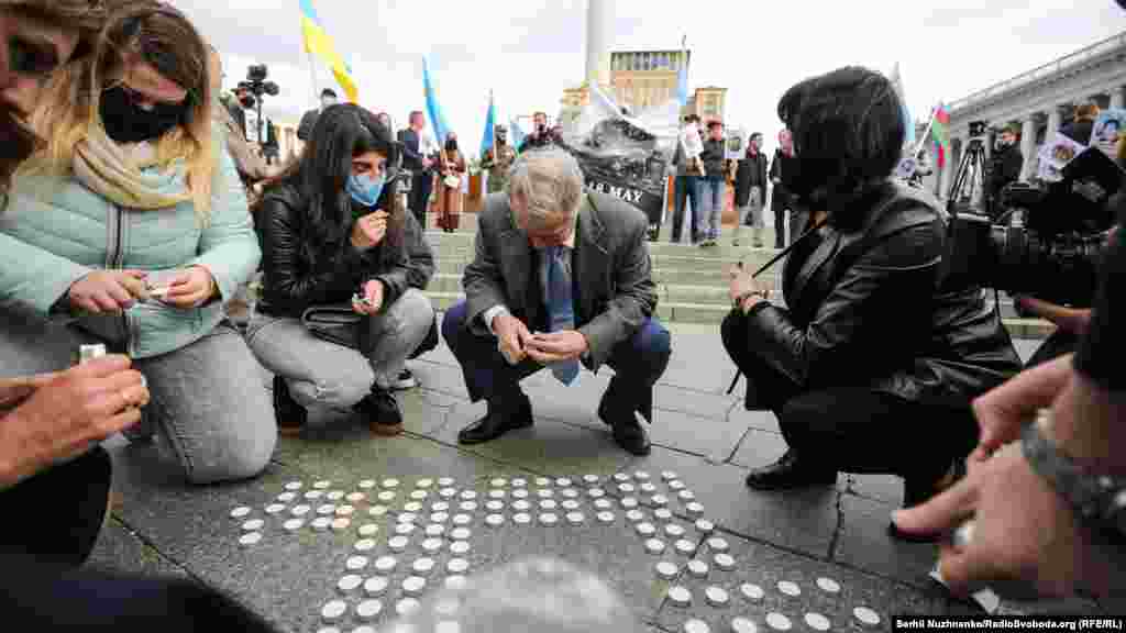 По окончанию акции участники зажгли свечи, выложенные в форме тамги (герба крымских татар)