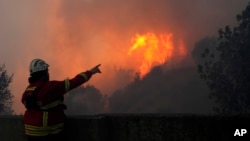 Një zjarrfikës i angazhuar për shuarjen e zjarreve në një pyll në periferi të Lisbonës. 25 korrik 2023.