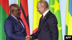 Russian President Vladimir Putin (right) and the president of Comoros and the chairman of the African Union, Azali Assoumani, shake hands in St. Petersburg on July 28.