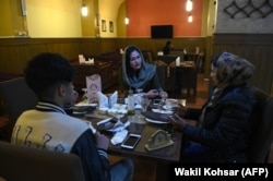 Young men and women talk over tea at a restaurant in Kabul in January 2019.