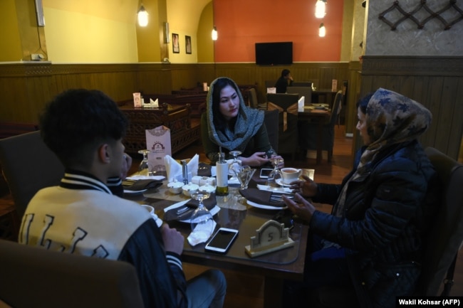 Të rinj dhe të reja bisedojnë duke pirë çaj në një restorant në Kabul në janar të vitit 2019.
