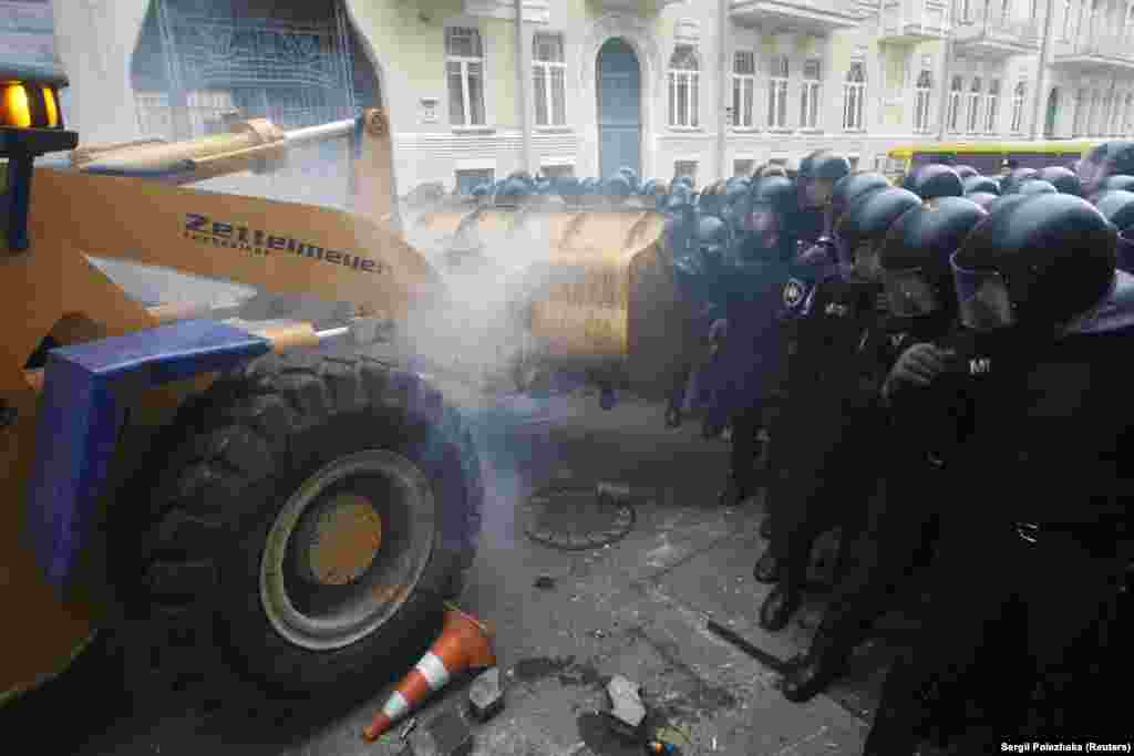 Протестующие пригнали трактор, чтобы попытаться прорвать ряды милиции вокруг здания президентской администрации.