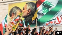 Supporters of Lebanon's Hezbollah hold pictures of Iran's Supreme Leader Ayatollah Ali Khamenei during a rally outside the Iranian Embassy in Beirut in June 2025.