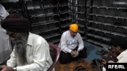 Khurshid Khan (in yellow head-covering) shining shoes to help show brotherhood with the Sikh community in Peshawar.