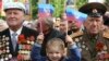 A child holds flags saying &quot;Luhansk Republic&quot; as he celebrates Victory Day with former Soviet servicemen during celebrations in the eastern Ukrainian city of Luhansk on May 9. (Reuters/Valentyn Ogirenko)