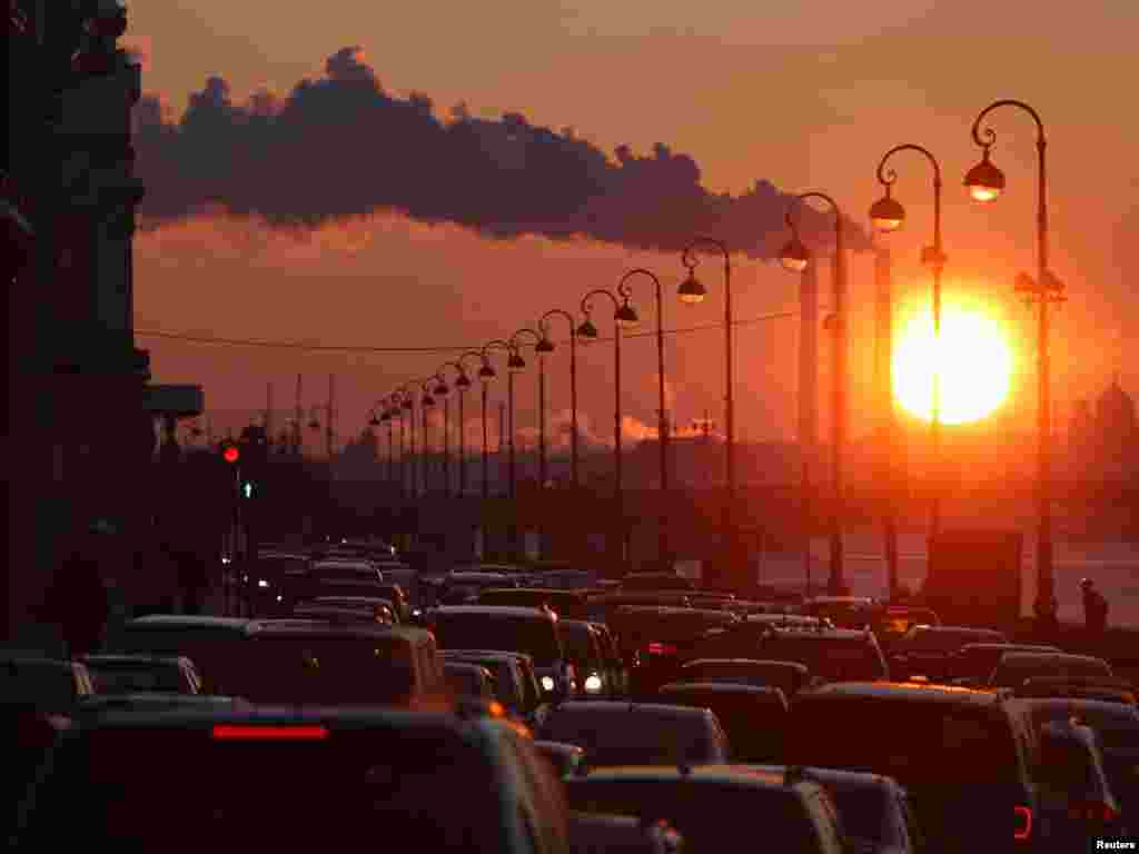 Pipes of a thermal power plant are seen during sunset, with cars stuck in a traffic jam in the foreground, in St. Petersburg on February 15.Photo by Aleksandr Demianchuk for Reuters