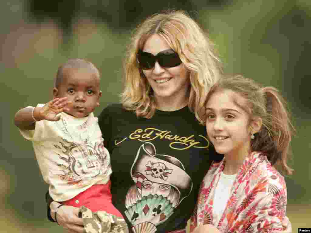 Madonna carries her adopted son David at the Home of Hope orphanage in Mchinji village,135 km (84 miles) west of the capital Lilongwe April 17,2007. Malawi police and stone-throwing school students blocked journalists from covering pop star Madonna's visit to an orphanage on Tuesday where the boy she is adopting was due to meet his biological father. At right is Madonna's daughter Lourdes. REUTERS/Siphiwe Sibeko