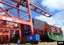 Një kamion transporton mallra në një port në Lianyungang të Kinës.