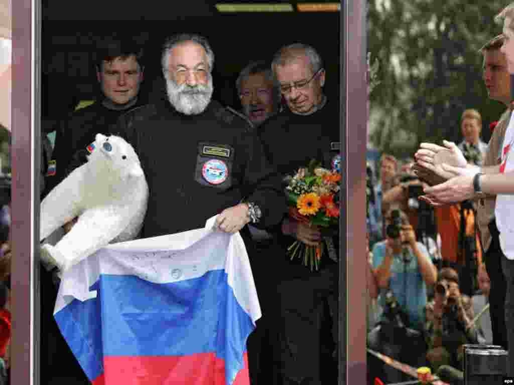 Russia - The head of Russian expedition Arctic-2007 Artur Chilingarov (C) carries the Russian flag and and a white bear toy as the crew of the expedition arrive in Moscow airport Vnukovo-3, 07Aug2007