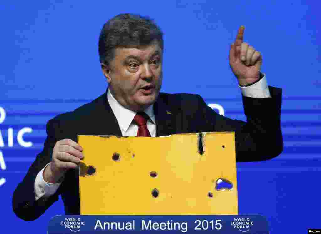 While speaking at the Davos forum, Ukrainian President Petro Poroshenko held up a fragment of the bus in which 12 civilians were killed in a rocket attack in eastern Ukraine. Kyiv blames pro-Russian separatists for the shelling, a charge denied by the rebels. (Reuters/Ruben Sprich)