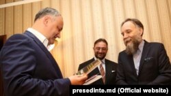 Președintele Republicii Moldova, Igor Dodon (stânga) și Aleksandr Dughin la, Chișinău, 27 mai 2017. Cu o lună înainte, Dughin lansase la București „Destin eurasianist”. Era însoțit de traducătorul său - Iurie Roșca.