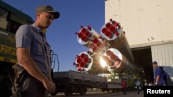 A policeman secures the area in front of the Soyuz TMA-05M spacecraft during its transportation to the launch pad at the Baikonur cosmodrome, Kazakhstan. 