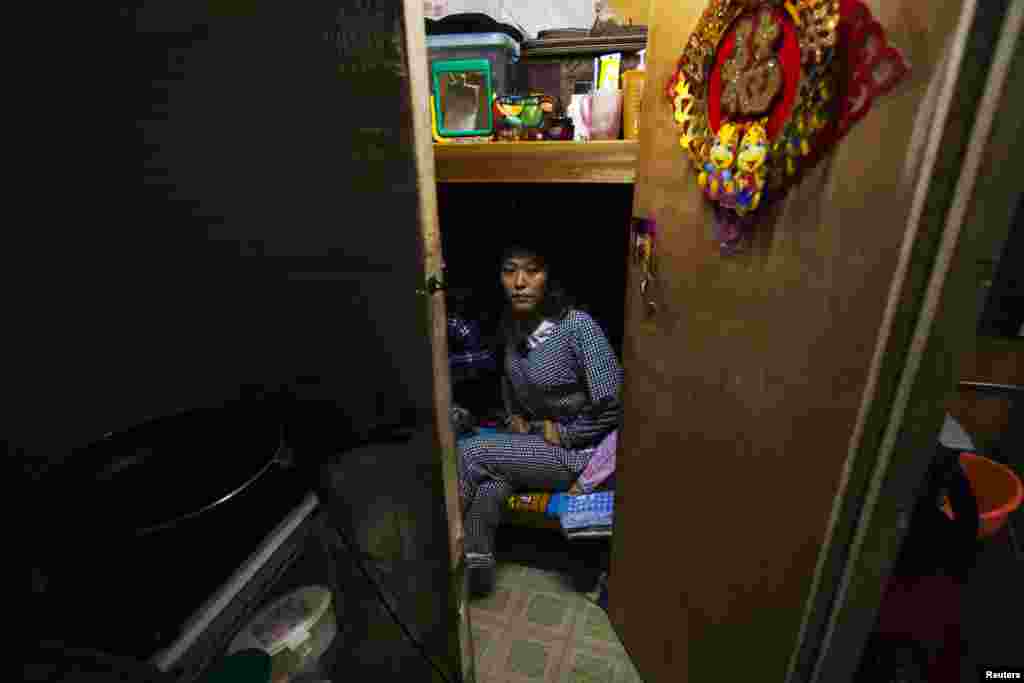 Thirty-seven-year-old Li Rong poses in her 3.2-square-meter subdivided flat inside an industrial building in Hong Kong. (2012 photo)