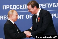 Russian President Vladimir Putin (left) shakes hands with Serbian President Aleksandar Vucic after being awarded the Order of Aleksander Nevsky in Belgrade in January 2019.