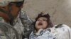U.S. Army First Sergeant Miguel Reyes holds a sick 11-month-old Afghan girl before an army medic conducts a medical check, during a patrol in the village of Gul Kalacheh in the Arghandab River valley, Kandahar Province, on September 19. <br /><br />Photo by Oleg Popov for Reuters