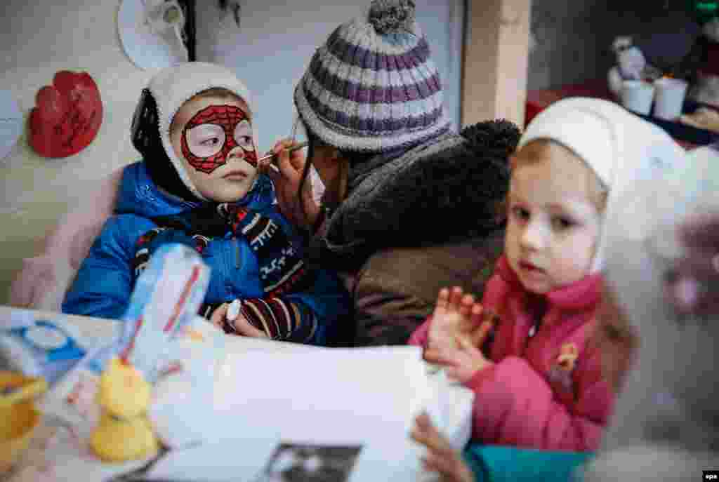 Volunteers in Kyiv paint children's faces during New Year celebrations for internally displaced persons from eastern Ukraine and Crimea. According to the UN, Ukraine has more than 600,000 IDPs from the conflict-affected areas. (epa/Roman Pilipey)