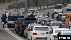 Armenia -- Police officers enforcing a coronavirus lockdown check cars leaving Yerevan, April 1, 2020.