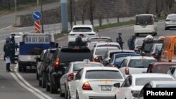 Armenia -- Police officers enforcing a coronavirus lockdown check cars leaving Yerevan, April 1, 2020.