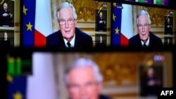 Michel Barnier pe monitoare TV în timpul unui interviu despre criza din țara sa, la 3 decembrie 2024. 