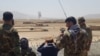 Afghan military officers watch clashes in Takhar in August. 