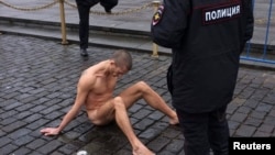 Police approach artist Pyotr Pavlensky during his protest on Red Square