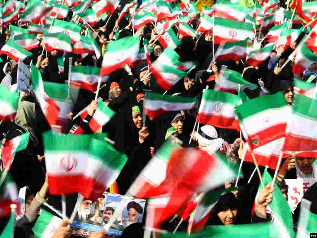 Female students in Tehran wave national flags during a ceremony marking the anniversary of the Islamic Revolution.
