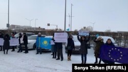 Группа активистов с флагами Казахстана и ЕС и плакатом с призывом освободить политических заключенных на акции протеста у представительства Европейского союза. Нур-Султан, 26 ноября 2019 года.