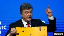 Президент Украины Петр Порошенко в Давосе с фрагментом автобуса, который обстреляли вблизи Волновахи