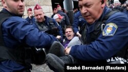 <p style="text-align: start;">Police officers carry a protester as demonstrators block the entrance of the parliament's garage on the day the Hungarian parliament voted on constitutional amendments targeting the LGBT community, in Budapest.<p style="text-align: start;"><br></p>