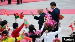 Afghanistan's President Ashraf Ghani and China's President Xi Jinping (R) wave to students during a welcoming ceremony outside the Great Hall of the People in Beijing. (File photo October 28, 2014)