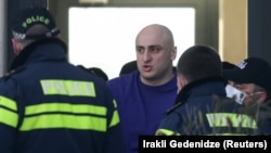 Georgian law enforcement officers detain opposition leader Nika Melia after storming his party's offices in Tbilisi early on February 23.