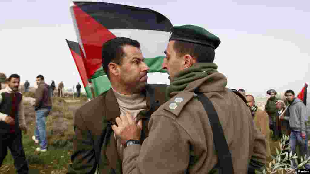 A Palestinian activist (left) argues with an Israeli border guard during a protest in the West Bank village of al-Janiya near Ramallah on February 8 (REUTERS/Mohamad Torokman)