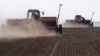 Agricultural workers plant soybeans near the village of Husachivka in the Kyiv region. 