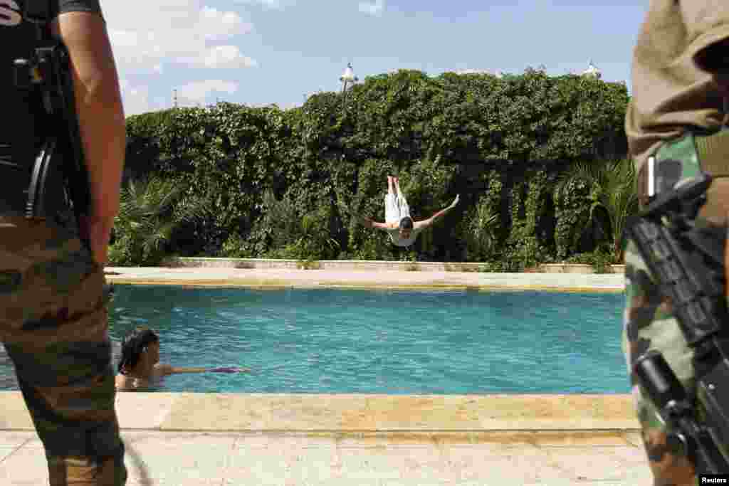 A member of the Free Syrian Army dives into a swimming pool in Aleppo. (Reuters/Hamid Khatib)