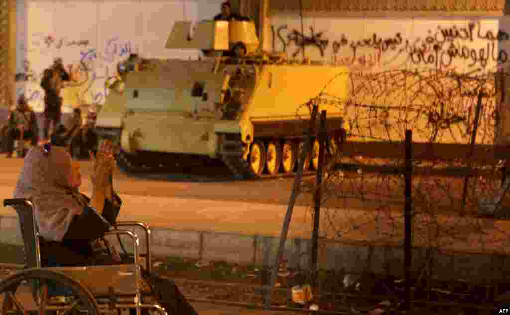 An Egyptian woman prays in a heavily guarded street outside the presidential palace in Cairo on December 15. (AFP/Patrick Baz)