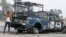 A protester stands next to the wreckage of an Iraqi police vehicle in Ramadi on December 30.