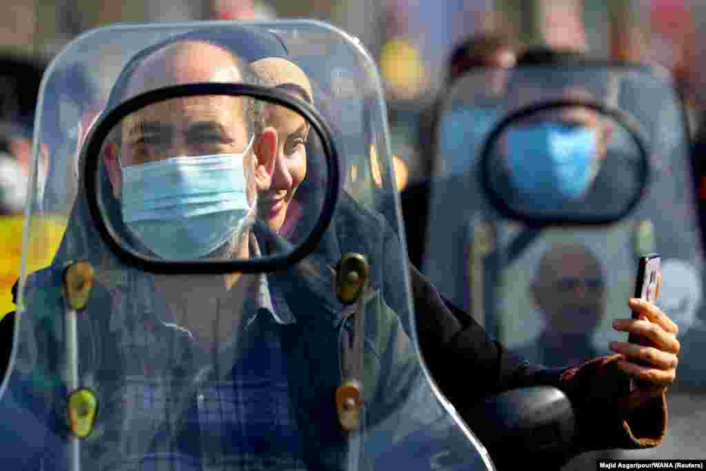 An Iranian woman takes a selfie as she rides on a motorcycle during the celebration of the 42nd anniversary of the Islamic Revolution in Tehran on February 10. (West Asia News Agency via Reuters/Majid Asgaripour)