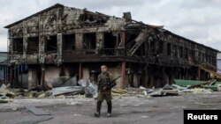 Бойовик угруповання «ДНР» біля заводу, зруйнованого внаслідок бойових дій, Нижня Кринка, 23 серпня 2014 року
